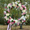 Large floral wreath with pink and white flowers on a metal stand
