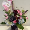 Pink and purple tulips, roses, hydrangeas and chrysanthemums arranged with white accents