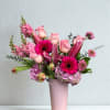 A vibrant mix of pink blooms featuring roses, gerber daisies, lilies and