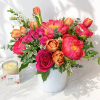 Bright mixed bouquet of pink and orange flowers in a white vase