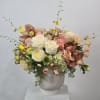 Bouquet of white and blush roses with peach orchids in a white vase