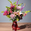 Mixed bouquet with lilies and pink chrysanthemums in a red vase