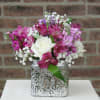Pink and white flower arrangement in a silver square vase