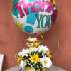 Daisy bouquet in a smiley-face vase with a colorful thank-you balloon