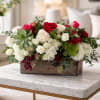 Arrangement of red and white roses in a wooden box