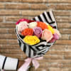 Bouquet of multicolored roses wrapped in black-and-white striped paper