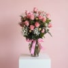 Pink rose bouquet in a glass vase with a pink ribbon