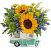 A contemporary and playful modern floral arrangement presented in a travel camper&ndash;style