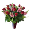 Red roses and pink snapdragons in a tall vase arrangement