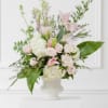 Pale pink lilies and roses with white hydrangeas and greens arranged in