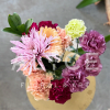 Carnations are skillfully arranged into a heart shape, accented with a gerbera