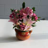 Bright pink lilies take center stage in this cheerful flower arrangement, a