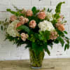 Peach roses and white hydrangeas in a glass vase