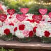 White and pink floral arrangements with red heart Valentine signs in glass vases