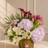 A fresh garden-style arrangement featuring tulips, hydrangeas, calla lilies, and delicate seasonal