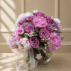 A romantic and elegant arrangement featuring lush pink peonies, lavender roses, alstroemeria