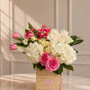 A soft and elegant arrangement featuring tulips, roses, hydrangeas, and seasonal blooms