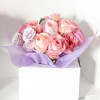 Pink and lavender rose bouquet wrapped in purple tissue paper