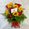 Bouquet of red roses and yellow sunflowers in a glass vase with a red ribbon