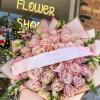 Large bouquet of pale pink roses wrapped in pink paper