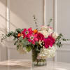 A luxurious arrangement of roses, lilies, hydrangeas, and fresh eucalyptus designed in