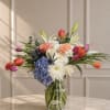 A cheerful and elegant arrangement featuring colorful tulips, hydrangeas, roses, lilies, and