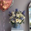 This vibrant flower arrangement combines cheerful Daisies, elegant Irises, romantic Roses, charming