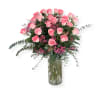 Pink roses arranged in a clear glass vase with small pink filler flowers