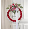 Standing funeral wreath with red roses, white flowers, and pink lilies
