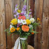 Colorful mixed bouquet in a glass vase with a white ribbon