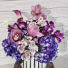 Pink and purple floral arrangement in a white vase