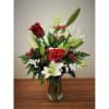 Red roses and white lilies arranged in a clear glass vase