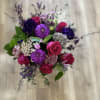 Bouquet of pink roses and purple flowers with greenery