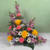 A clear glass cross nestled at the heart of softly layered blooms
