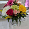 Mixed seasonal blooms in a decorative p Mason jar