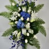 Tall blue and white floral spray with lilies, roses, and ferns