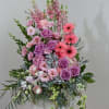Tall pink and purple floral arrangement with roses and gerbera daisies