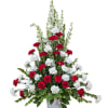 Red and white carnations in a white vase