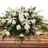 White floral casket spray with lilies and carnations