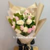 Bouquet of pink and white roses wrapped in beige paper