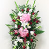 Standing floral spray with pink hydrangeas, red roses, and white lilies