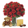Red rose and carnation bouquet in a glass vase with a teddy bear and chocolates