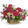 Pink roses and carnations in a wooden box