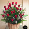 Basket arrangement of tall red roses with white filler flowers and ferns.