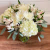 White bouquet with hydrangea, chrysanthemums, and pale pink alstroemeria in a glass vase