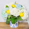 Blue and white hydrangeas with lemons in a patterned vase