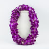 Purple orchid lei draped over a light fabric display form