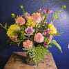Mixed bouquet in a clear glass vase with pink, yellow, and lavender blooms
