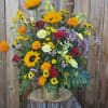 Mixed bouquet of sunflowers, roses, and marigolds in a gold vase