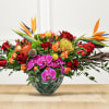 Tropical bouquet with red roses and purple orchids in a glass vase